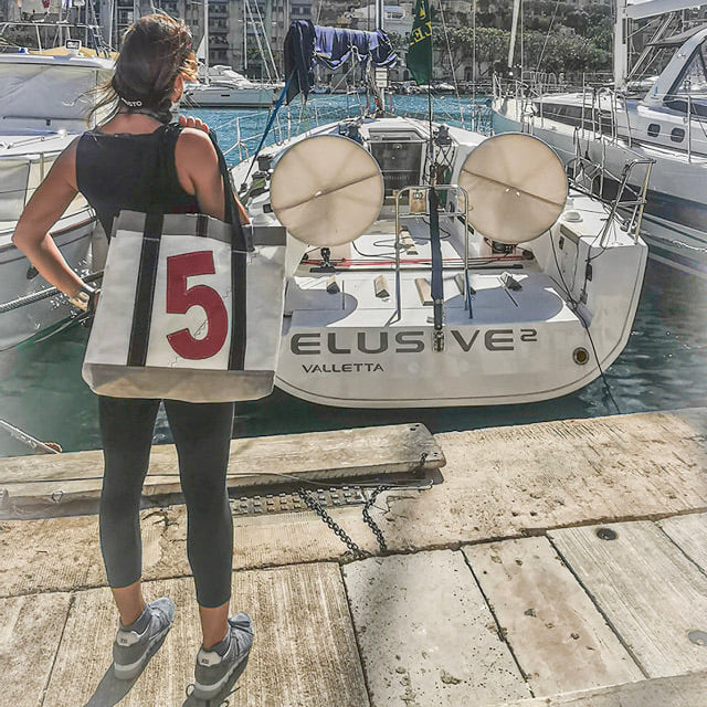 Proud owner of the tote bag after winning the Middle sea race in front of her yacht.

